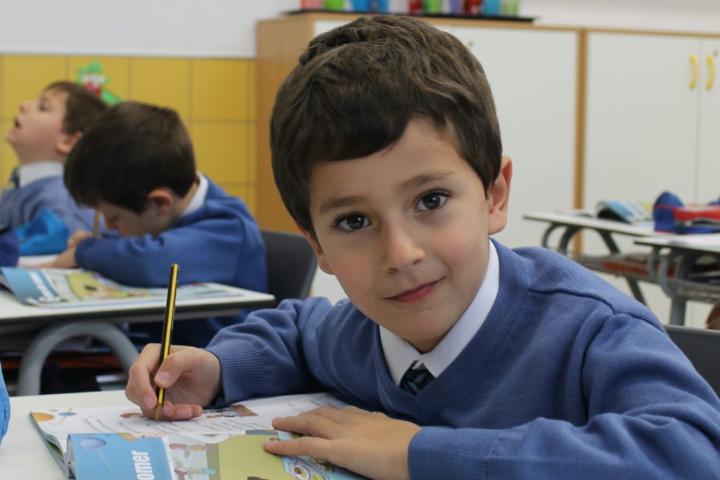 Imagen de niño escribiendo en su pupitre para ilustrar la sección "Tarfias" dentro de "Matrículas"